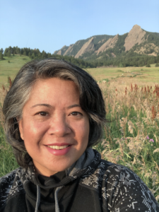 Natasha Vizcarra, a freelance science writer and editor, stands in front of the Boulder Flatirons in Chautaqua Park, Boulder, Colorado.